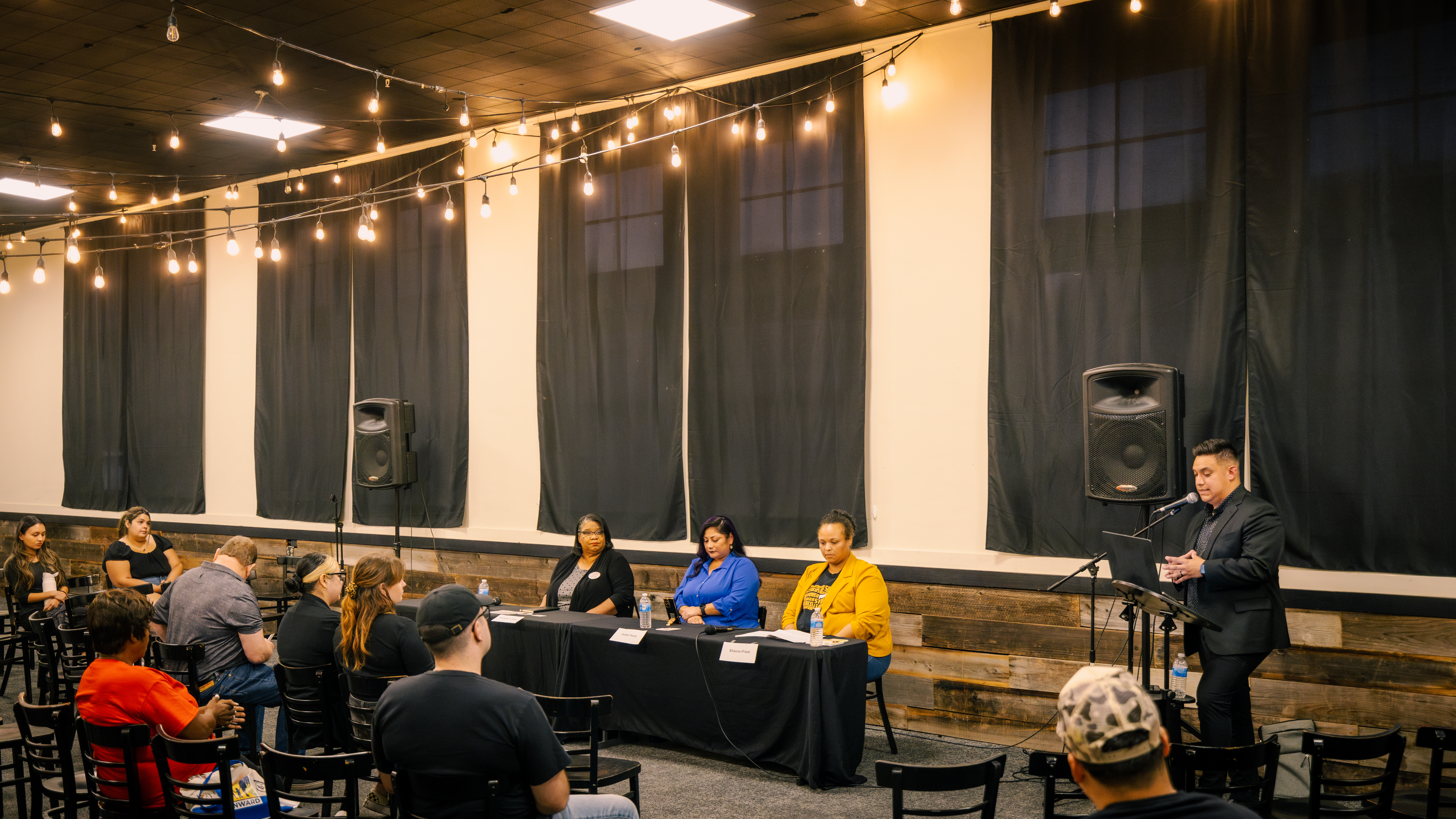 Candidates at the Stockton School Board Candidate Forum, hosted by Fat City Feed in collaboration with Teach for America-California Capital Valley, listen attentively as the moderator introduces the evening's agenda.